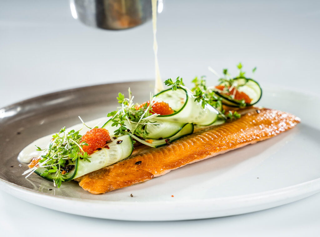 Bilde av stekt fisk som danderes på fat med tilbehør